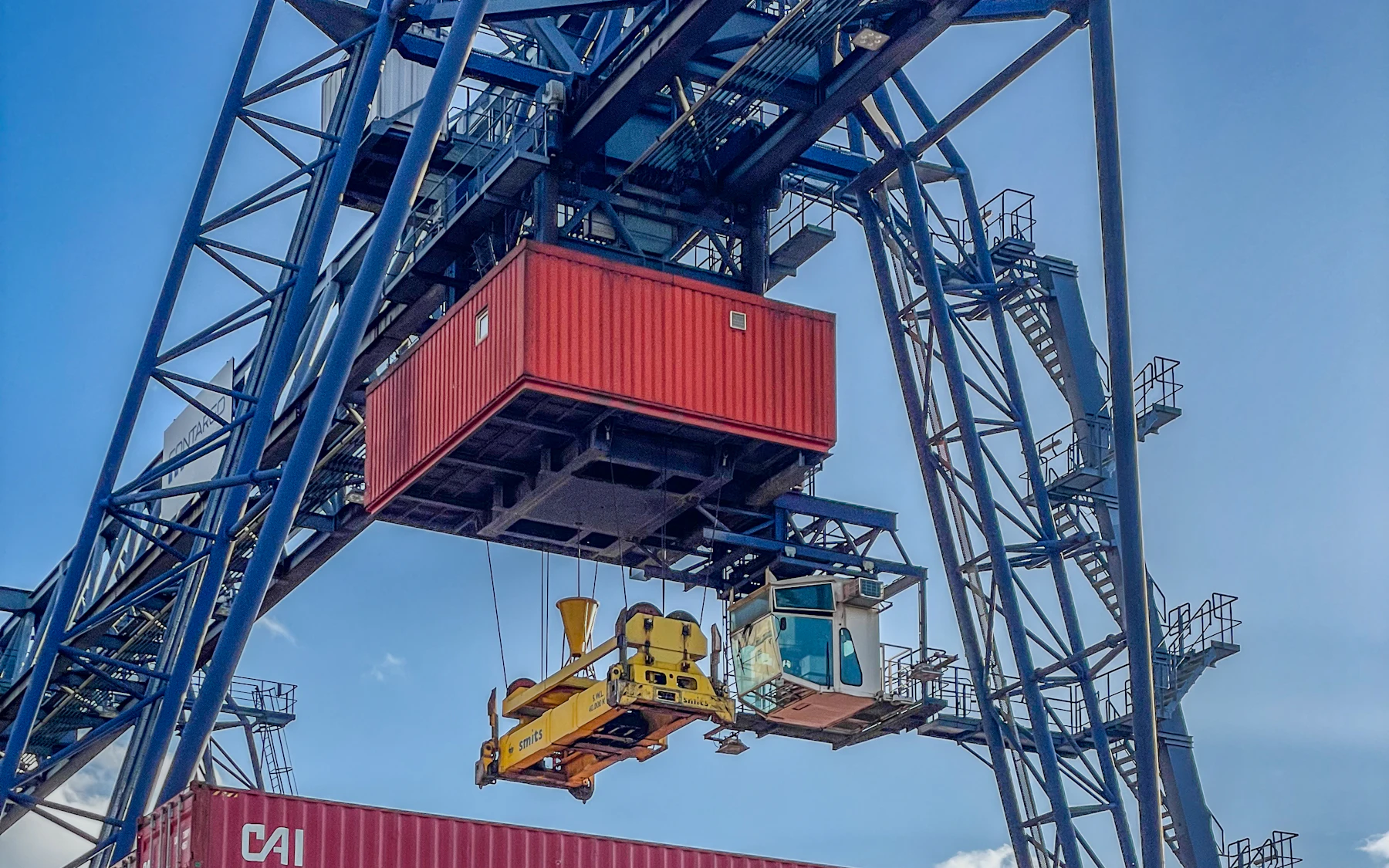 Intermodal crane transferring a container during logistics operations